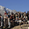 Men play traditional instruments and are entertained by a young boy dancing in the early morning on the day of the Polo final Shandur Pass, Chitral province, Pakistan.